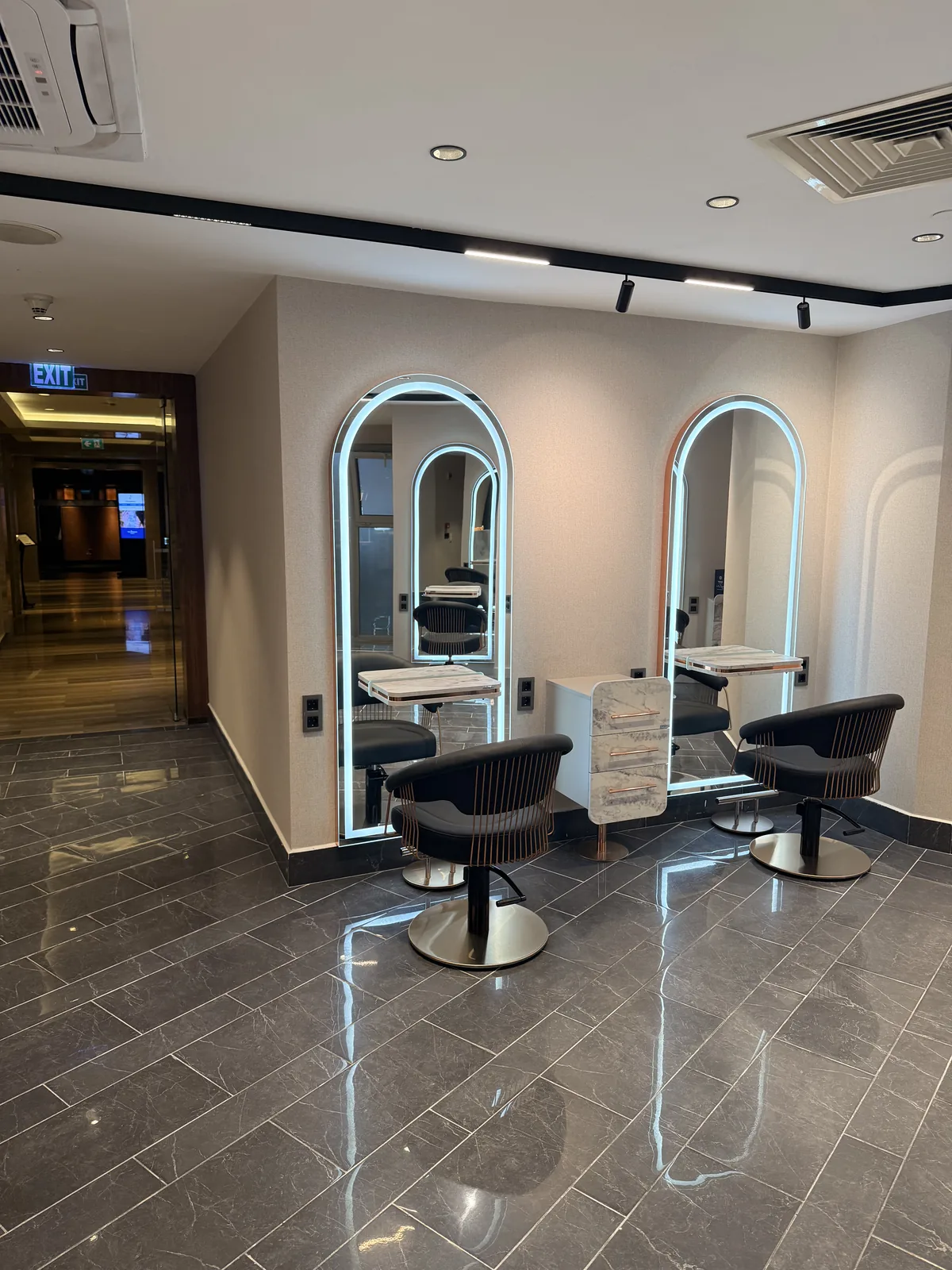 Élite Coiffeur Taksim kuaför — aydınlatmalı kemerli aynalar ve koltuklar